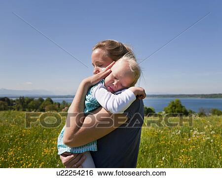 Woman holding daughter in field View Large Photo Image Stock Photograph - Woman holding daughter in field. Fotosearch