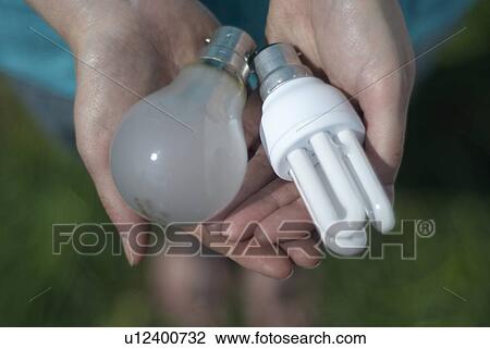 Woman holding different light bulbs View Large Photo Image Stock Image - Woman holding different light bulbs. Fotosearch