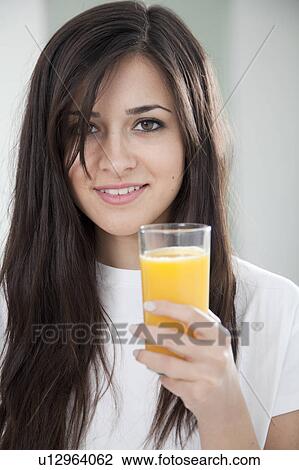 Woman holding glass of orange juice View Large Photo Image Stock Image - Woman holding glass of orange juice. Fotosearch