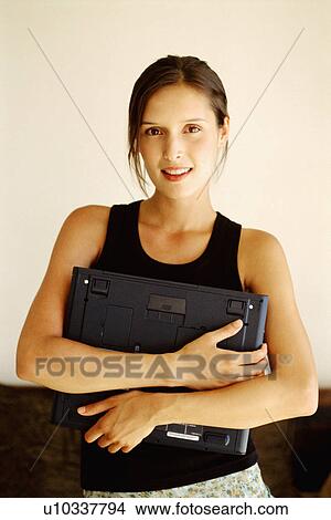 Picture - Woman holding laptop. Fotosearch