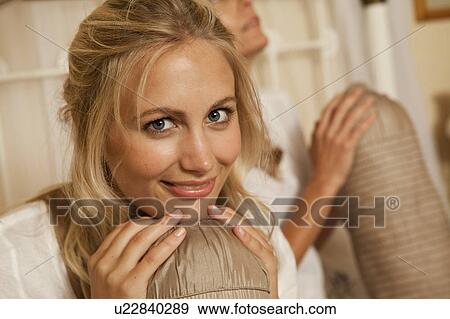Woman holding pillow in bed View Large Photo Image Stock Photo - Woman holding pillow in bed. Fotosearch