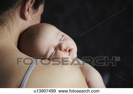 Stock Photo - Woman holding sleeping baby. Fotosearch