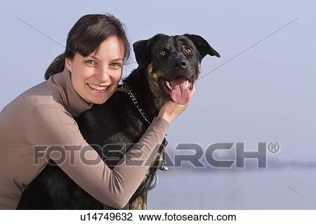 Woman hugging dog outdoors View Large Photo Image Stock Image - Woman hugging dog outdoors. Fotosearch