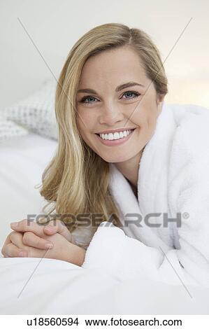 Woman in bathrobe laying on bed View Large Photo Image Picture - Woman in bathrobe laying on bed. Fotosearch