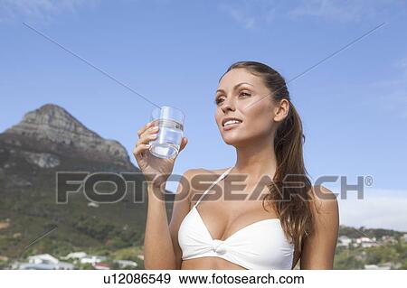 Stock Photo - Woman in bikini drinking glass of water. Fotosearch