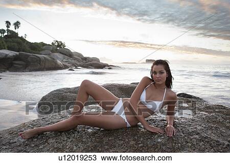 Woman in bikini laying on beach View Large Photo Image Stock Image - Woman in bikini laying on beach. Fotosearch