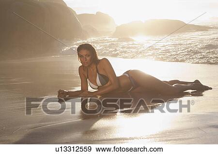 Stock Photo - Woman in bikini laying on beach. Fotosearch