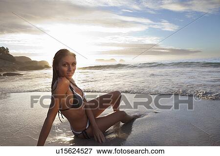 Stock Photo - Woman in bikini laying on beach. Fotosearch