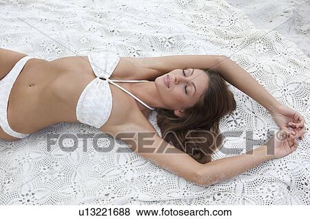 Woman in bikini laying on blanket View Large Photo Image Stock Photo - Woman in bikini laying on blanket. Fotosearch