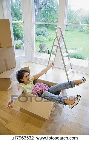 Woman in cardboard box in new home View Large Photo Image Stock Image - Woman in cardboard box in new home. Fotosearch