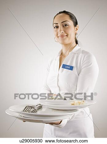 Woman in nametag carrying empty plates View Large Photo Image Stock Image - Woman in nametag carrying empty plates. Fotosearch