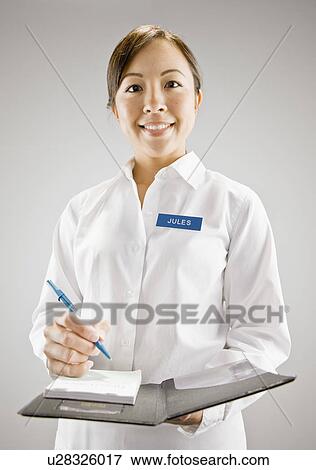 Stock Photo - Woman in nametag taking an order. Fotosearch