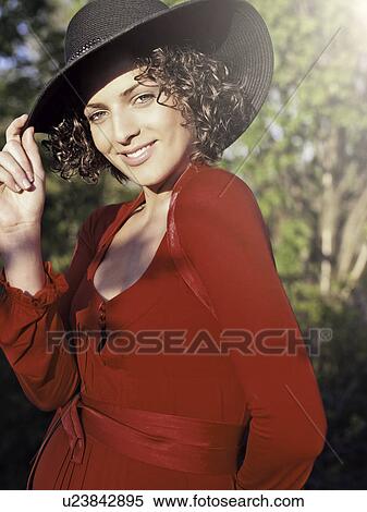 Stock Photography - Woman in red dress wearing sunhat. Fotosearch