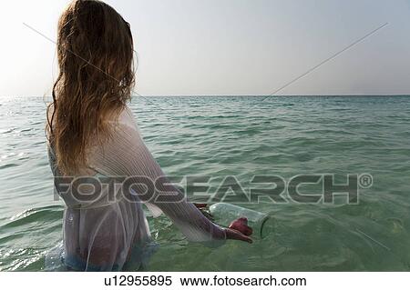 Woman in sea with message in a bottle View Large Photo Image Stock Photography - Woman in sea with message in a bottle. Fotosearch