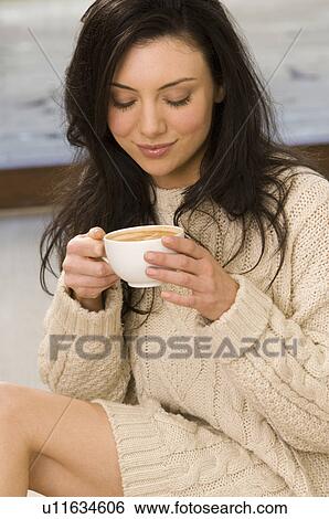 Stock Photograph - Woman in sweater having cup of coffee. Fotosearch
