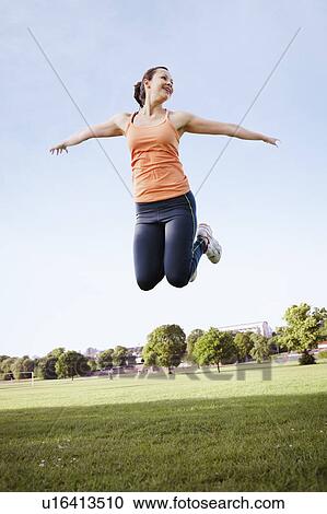 Woman jumping in park View Large Photo Image Stock Image - Woman jumping in park. Fotosearch