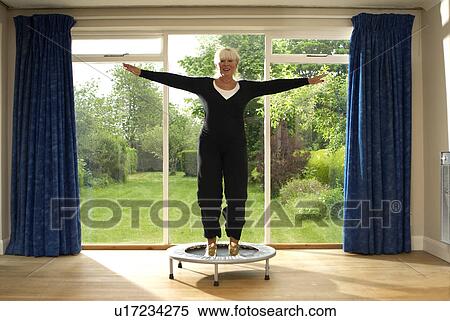 Woman jumping on exercise trampoline View Large Photo Image Stock Photography - Woman jumping on exercise trampoline. Fotosearch