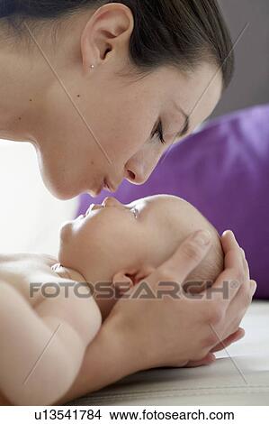 Woman kissing baby at home View Large Photo Image Picture - Woman kissing baby at home. Fotosearch