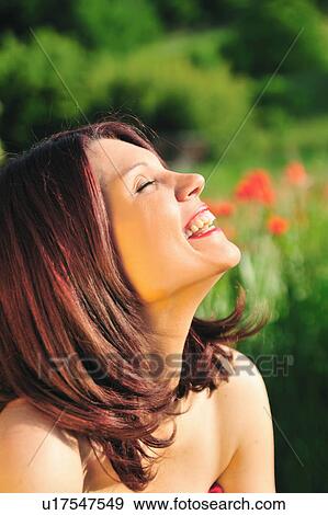 Stock Photo - Woman laughing in field. Fotosearch