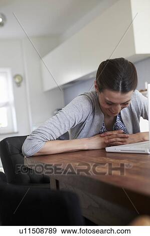 Woman laughing in front of laptop View Large Photo Image Stock Photo - Woman laughing in front of laptop. Fotosearch