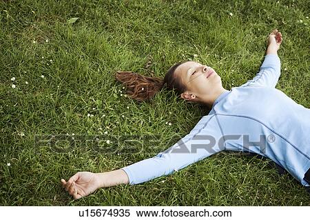 Woman laying in grass at park View Large Photo Image Stock Photography - Woman laying in grass at park. Fotosearch