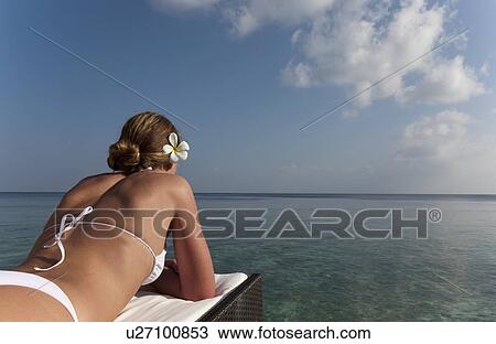 Woman laying on daybed overlooking sea View Large Photo Image Stock Image - Woman laying on daybed overlooking sea. Fotosearch