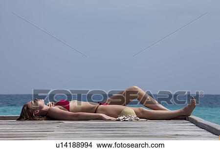 Woman laying on deck overlooking sea View Large Photo Image Picture - Woman laying on deck overlooking sea. Fotosearch