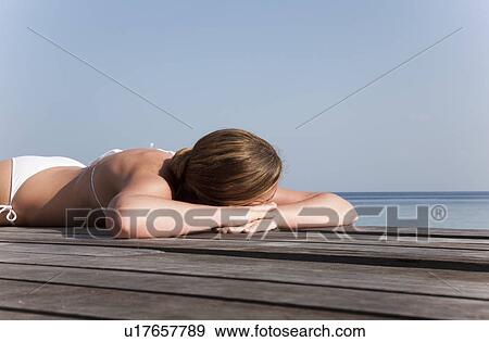 Woman laying on deck overlooking sea View Large Photo Image Stock Photo - Woman laying on deck overlooking sea. Fotosearch