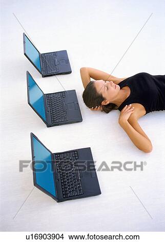Woman laying on floor with laptops View Large Photo Image Picture - Woman laying on floor with laptops. Fotosearch