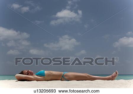 Woman laying on tropical beach View Large Photo Image Stock Image - Woman laying on tropical beach. Fotosearch