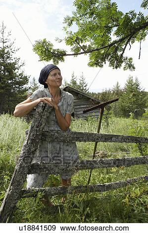 Woman leaning on wooden fence View Large Photo Image Stock Photo - Woman leaning on wooden fence. Fotosearch