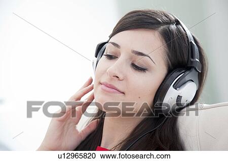 Stock Image - Woman listening to headphones. Fotosearch