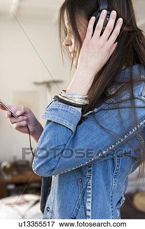 Woman listening to headphones View Large Photo Image Stock Photo - Woman listening to headphones. Fotosearch
