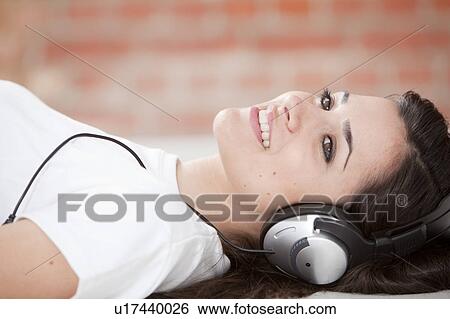 Stock Photograph - Woman listening to headphones. Fotosearch