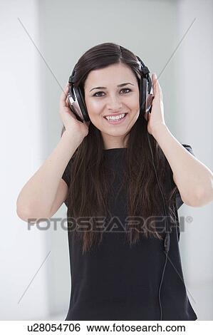 Stock Photograph - Woman listening to headphones. Fotosearch