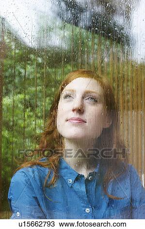 Woman looking outside on rainy day View Large Photo Image Stock Image - Woman looking outside on rainy day. Fotosearch