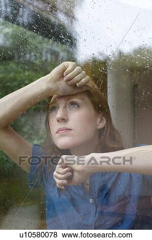 Woman looking outside on rainy day View Large Photo Image Stock Photo - Woman looking outside on rainy day. Fotosearch