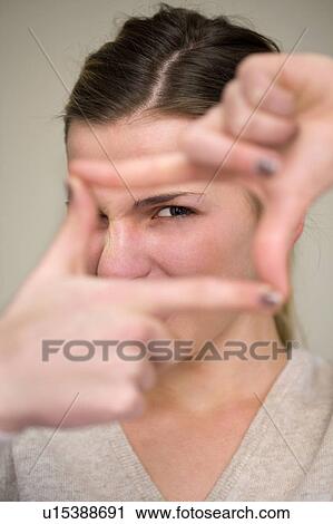 Stock Image - Woman making frame with fingers. Fotosearch