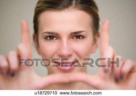 Stock Image - Woman making frame with fingers. Fotosearch