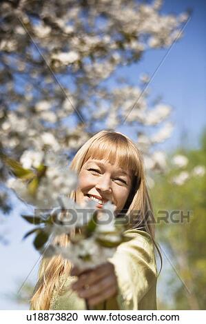 Woman offering flowers outdoors View Large Photo Image Stock Image - Woman offering flowers outdoors. Fotosearch