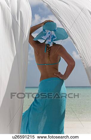 Stock Photography - Woman on beach behind white curtains. Fotosearch