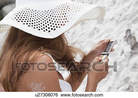 Woman on beach using cell phone View Large Photo Image Stock Photograph - Woman on beach using cell phone. Fotosearch