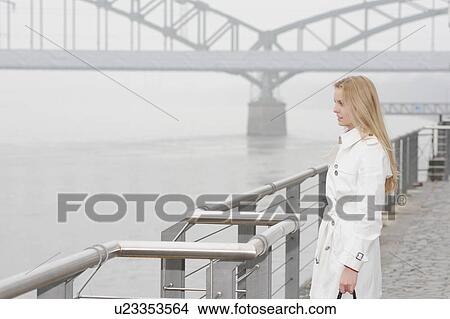 Woman overlooking city river View Large Photo Image Picture - Woman overlooking city river. Fotosearch