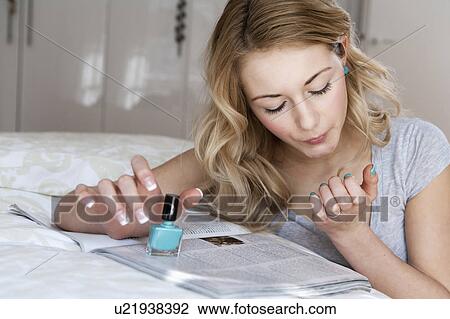 Woman painting her nails in bedroom View Large Photo Image Stock Image - Woman painting her nails in bedroom. Fotosearch