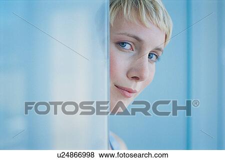 Stock Photo - Woman peeking around doorway. Fotosearch