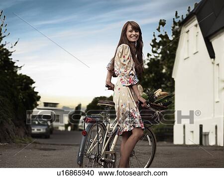 Woman pushing bicycle along rural road View Large Photo Image Stock Image - Woman pushing bicycle along rural road. Fotosearch
