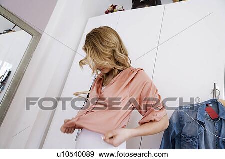 Woman putting on sweater View Large Photo Image Stock Photo - Woman putting on sweater. Fotosearch