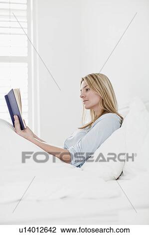 Woman reading book in bed View Large Photo Image Stock Image - Woman reading book in bed. Fotosearch