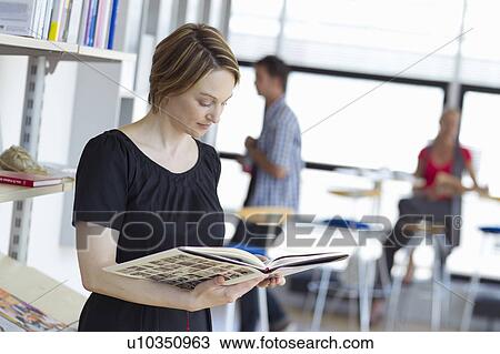 Woman reading book in library View Large Photo Image Stock Image - Woman reading book in library. Fotosearch