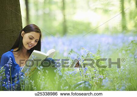 Woman reading in field of flowers View Large Photo Image Stock Photograph - Woman reading in field of flowers. Fotosearch